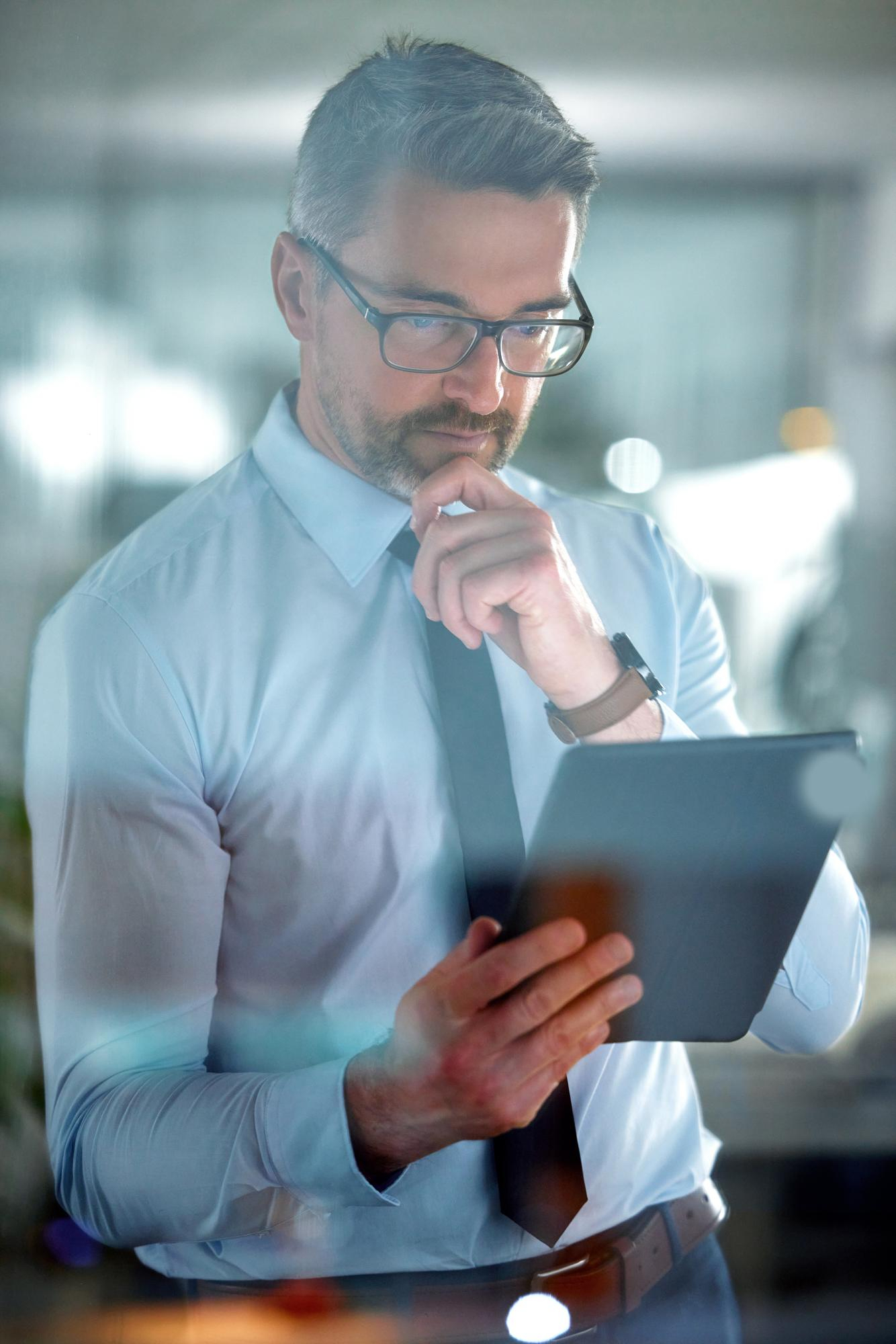Executivo analisando dados e informações corporativas em tablet